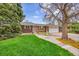 Charming brick home features a lush front lawn, mature trees, and a welcoming two-car garage at 11157 W Marlowe Ave, Jefferson, CO 80127