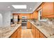 Bright kitchen with granite counters, stainless steel appliances, a skylight, and wood cabinetry at 11157 W Marlowe Ave, Jefferson, CO 80127