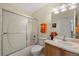 Bright bathroom featuring a single vanity and shower over tub with glass doors at 13151 Ivanhoe St, Thornton, CO 80602