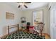 Bright bedroom with hardwood floors, ceiling fan, and window with backyard view at 13151 Ivanhoe St, Thornton, CO 80602