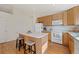 Well-lit kitchen featuring hardwood floors, white appliances, and an island with bar seating at 13151 Ivanhoe St, Thornton, CO 80602