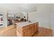 Kitchen island with wood cabinets in an open space, seamlessly connected to the dining and living areas at 13151 Ivanhoe St, Thornton, CO 80602