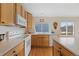 Well-lit kitchen with ample counter space, wood cabinets, modern appliances, and a window view at 13151 Ivanhoe St, Thornton, CO 80602