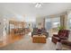 Bright living room with large windows, ceiling fan, and open-concept layout to the kitchen at 13151 Ivanhoe St, Thornton, CO 80602