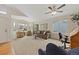 Spacious living room featuring neutral carpet, large windows, and a ceiling fan at 13151 Ivanhoe St, Thornton, CO 80602