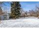 Snowy backyard featuring a large evergreen tree and storage shed along the wooden privacy fence at 4693 Chatham St, Boulder, CO 80301