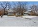 Spacious snow covered backyard with patio seating area and view of the home's enclosed sunroom at 4693 Chatham St, Boulder, CO 80301