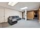 Finished basement space featuring a sectional sofa, carpeted floors, and access to the upper level at 4693 Chatham St, Boulder, CO 80301