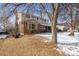 Side view of a charming two-story home with a brick facade and snow covered front yard at 4693 Chatham St, Boulder, CO 80301