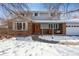 Charming two-story home featuring a brick facade, covered porch with swing, and a snow-covered front yard at 4693 Chatham St, Boulder, CO 80301