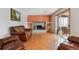 Cozy living room with a brick fireplace, built-in shelving, wood floors, and comfortable leather seating at 4693 Chatham St, Boulder, CO 80301