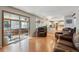 Comfortable living room with hardwood floors, a sunroom view, and an open layout to the bright kitchen at 4693 Chatham St, Boulder, CO 80301