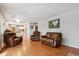 Inviting living room with hardwood floors and leather furniture, seamlessly connecting to an open-plan kitchen area at 4693 Chatham St, Boulder, CO 80301