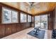 Wood-paneled sunroom featuring lots of natural light, access to a patio and space for exercise equipment at 4693 Chatham St, Boulder, CO 80301
