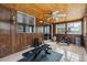 Bright sunroom with wood paneling, tiled floors, windows and exercise equipment at 4693 Chatham St, Boulder, CO 80301