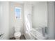 Modern bathroom with floating sink, toilet and a window at 3481 W 63Rd Ave, Denver, CO 80221