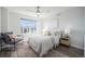 Bright bedroom with a ceiling fan, comfortable chair, and a large window offering neighborhood views at 3481 W 63Rd Ave, Denver, CO 80221