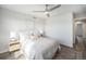 Bedroom with a ceiling fan, bedside tables with lamps, and a large bed layered with pillows and comforters at 3481 W 63Rd Ave, Denver, CO 80221