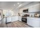 Modern kitchen with stainless steel appliances, white cabinetry, and stylish backsplash at 3481 W 63Rd Ave, Denver, CO 80221