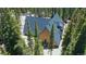 Aerial view of a unique A-frame cabin nestled amongst tall pine trees and surrounded by nature at 297 Robertson Ln, Breckenridge, CO 80424