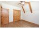 Bedroom with exposed beams, wood floors and a wood closet doors at 297 Robertson Ln, Breckenridge, CO 80424
