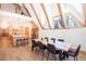 Open dining room features A-frame construction, exposed beams, wood floors, and adjacent island kitchen at 297 Robertson Ln, Breckenridge, CO 80424