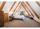Main bedroom featuring vaulted ceilings with wooden beams and a cozy balcony overlooking the forest at 297 Robertson Ln, Breckenridge, CO 80424