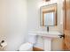 Elegant powder room with a modern pedestal sink, sleek fixtures, and a well-lit mirror for a clean aesthetic at 297 Robertson Ln, Breckenridge, CO 80424