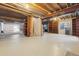 Unfinished basement with exposed ceiling, built-in shelving, and a large open space at 6393 S Jamaica Ct, Englewood, CO 80111