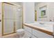 Bathroom with a gold framed sliding glass shower, white vanity, and toilet at 6393 S Jamaica Ct, Englewood, CO 80111