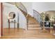Elegant foyer featuring wood floors, a grand staircase, and stylish decor creating a welcoming entrance at 6393 S Jamaica Ct, Englewood, CO 80111