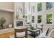 Living room with high ceilings, a fireplace, and large windows, perfect for relaxing and enjoying the view of the outdoors at 6393 S Jamaica Ct, Englewood, CO 80111