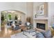 Open-concept living room connected to a dining area featuring a fireplace and large windows offering plenty of natural light at 6393 S Jamaica Ct, Englewood, CO 80111