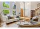 Bright living room with a soaring ceiling, hardwood floors, large windows, and comfortable seating for entertaining guests at 6393 S Jamaica Ct, Englewood, CO 80111