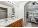 Bright bathroom with double sinks, wood cabinets, and a view into the Primary bedroom, offering a spa-like experience at 8200 E 8Th Ave # 5-204, Denver, CO 80230
