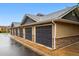 A row of detached garages with dark gray doors and stone accents under a blue sky at 8200 E 8Th Ave # 5-204, Denver, CO 80230