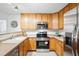Well-equipped kitchen with wood cabinets, stainless steel appliances, and a breakfast bar, great for meal prep at 8200 E 8Th Ave # 5-204, Denver, CO 80230