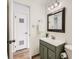 Updated bathroom with a green vanity, framed mirror, and modern lighting fixtures at 2301 E Fremont Ave # W03, Centennial, CO 80122