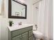 Well-lit bathroom with a large mirror, green vanity, and shower-tub combination at 2301 E Fremont Ave # W03, Centennial, CO 80122
