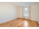 Sun-filled bedroom featuring hardwood floors, a large window, and neutral-toned curtains at 2301 E Fremont Ave # W03, Centennial, CO 80122