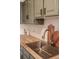 Modern kitchen with butcher block countertops, stainless steel sink, and stylish hexagon backsplash at 2301 E Fremont Ave # W03, Centennial, CO 80122