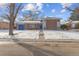 Ranch style home with a blue garage door and snowy yard at 12352 E 30Th Ave, Aurora, CO 80011