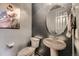 Small powder room with pedestal sink, toilet and oval mirror at 3438 Cade Ct, Castle Rock, CO 80104