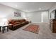 Spacious basement recreation room featuring a comfortable leather sectional sofa at 7394 S Scottsburg Way, Aurora, CO 80016