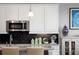 Kitchen features white cabinets and granite countertops at 7394 S Scottsburg Way, Aurora, CO 80016