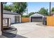View of the home's backyard with a detached garage, new fence, and concrete patio at 4645 E Florida Ave, Denver, CO 80222