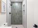 Walk-in shower features decorative shower tile, a rainfall shower head, and a built-in shampoo niche at 4645 E Florida Ave, Denver, CO 80222