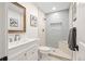 Bright bathroom with updated vanity, framed mirror, and walk-in shower with gray tile surround at 4645 E Florida Ave, Denver, CO 80222