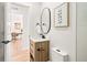 Half-bathroom features a modern vanity, a black faucet, and a decorative mirror and artwork at 4645 E Florida Ave, Denver, CO 80222