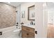 Bright bathroom featuring a tub with herringbone tile, a wooden vanity, and modern fixtures at 4645 E Florida Ave, Denver, CO 80222
